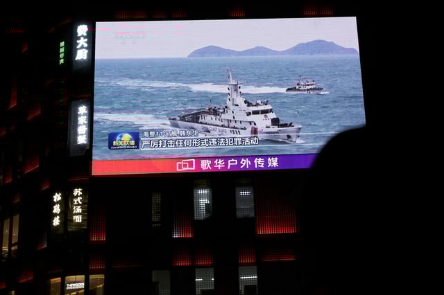 Un navire de la Garde côtière chinoise croisant au large de Taïwan est vu sur un écran géant devant un centre commercial à Pékin, Chine, le 1er avril 2025.