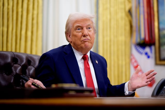 President Donald Trump sits at his desk in the Oval Office.