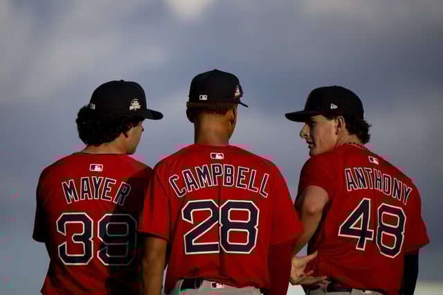 Marcelo Mayer #39 of the Boston Red Sox, Kristian Campbell #28 of the Boston Red Sox, and Roman Anthony #48 of the Boston Red Sox line up for the National Anthem before a 2025 MLB Spring Breakout game against the Tampa Bay Rays at Charlotte Sports Park on March 13, 2025 in Port Charlotte, Florida.