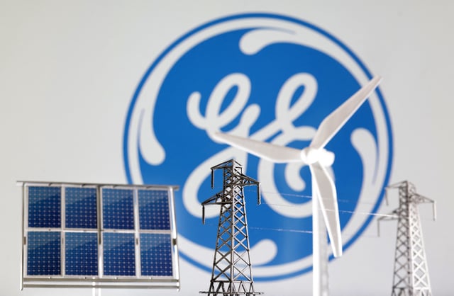 Miniatures of windmill, solar panel and electric pole are seen in front of General Electric logo in this illustration taken January 17, 2023. REUTERS/Dado Ruvic/Illustration/File Photo