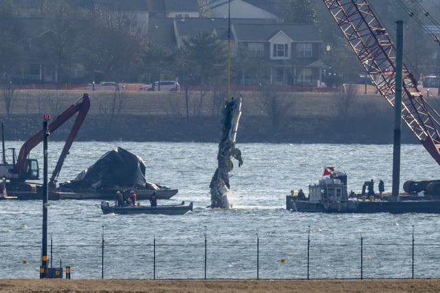 FILE - A piece of wreckage is lifted from the water onto a salvage vessel near the site in the Potomac River of a mid-air collision between an American Airlines jet and a Black Hawk helicopter, at Ronald Reagan Washington National Airport, Feb. 4, 2025, in Arlington, Va. (AP Photo/Ben Curtis, File)