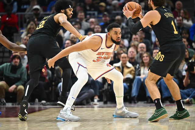 Karl-Anthony Towns #32 of the New York Knicks guards Max Strus #1 of the Cleveland Cavaliers during the third quarter at Rocket Arena on February 21, 2025 in Cleveland, Ohio.