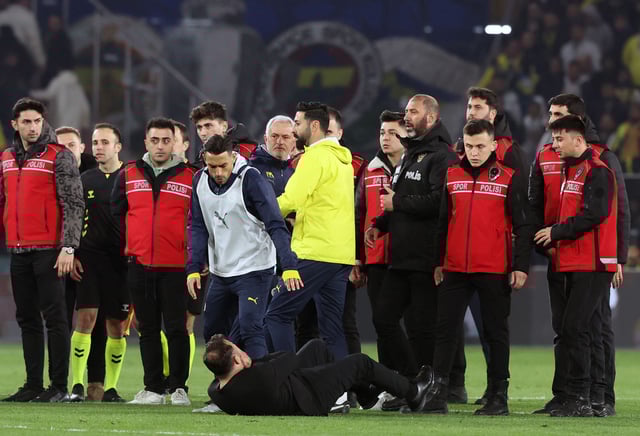 Galatasaray manager Okan Buruk falls to the ground after getting his nose pinched by Fenerbahçe manager Jose Mourinho on Wednesday in Istanbul, Turkey.