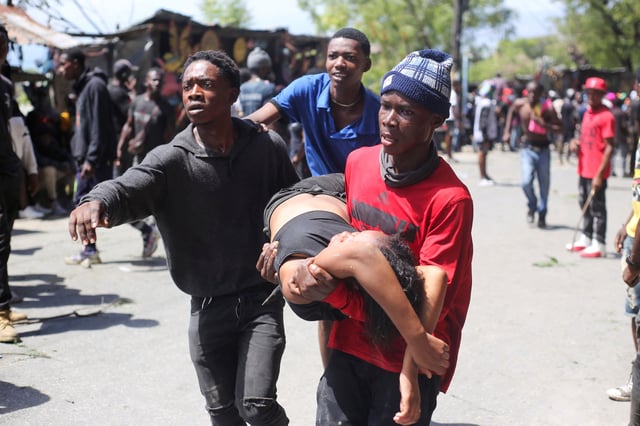 A woman is carried by demonstrators after being reached by tear gas used by police officers during a protest against insecurity, in Port-au-Prince, Haiti April 2, 2025. REUTERS/Jean Feguens Regala
