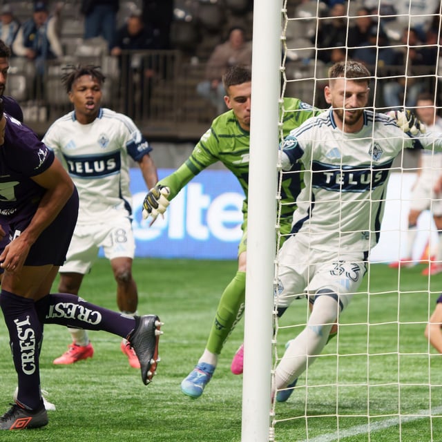 Vancouver Whitecaps' Tristan Blackmon (right) is grabbed by Pumas UNAM goalkeeper Alex Padilla as the ball enters the goal during the second half of a CONCACAF Champions Cup quarterfinal soccer match, in Vancouver, on Wednesday, April 2, 2025. THE CANADIAN PRESS/Christopher Morris