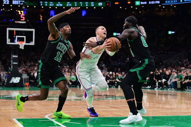 Apr 2, 2025; Boston, Massachusetts, USA; Miami Heat guard Tyler Herro (14) controls the ball between Boston Celtics forward Torrey Craig (12) and center Neemias Queta (88) during the first half at TD Garden. Mandatory Credit: Bob DeChiara-Imagn Images