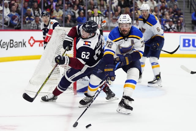 Mar 29, 2025; Denver, Colorado, USA; St. Louis Blues defenseman Justin Faulk (72) and Colorado Avalanche left wing Artturi Lehkonen (62) battle for the puck in the second period at Ball Arena. Mandatory Credit: Ron Chenoy-Imagn Images