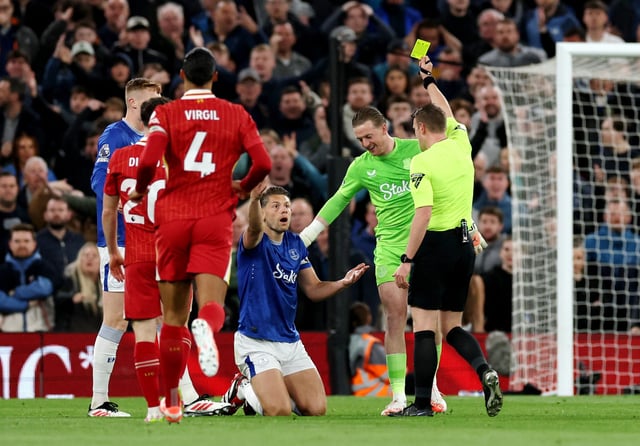 Soccer Football - Premier League - Liverpool v Everton - Anfield, Liverpool, Britain - April 2, 2025 Everton's James Tarkowski is shown a yellow card by referee Samuel Barrott REUTERS/Phil Noble/File Photo