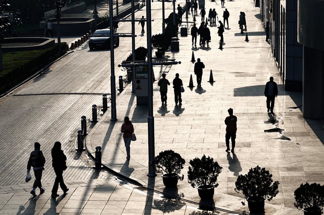 People walk past an office and shopping complex in Beijing, China April 10, 2024. REUTERS/Tingshu Wang/File Photo