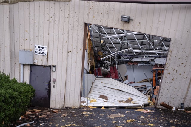 A shipping and receiving bay door is damaged along with the interior of the Gordon-Hardy building after a tornado passed through an industrial industrial park on Thursday, April 3, 2025, in Jeffersontown, Ky. (AP Photo/Jon Cherry)