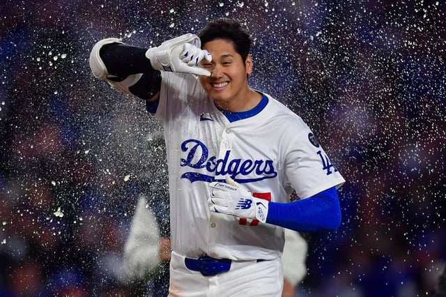 Apr 2, 2025; Los Angeles, California, USA; Los Angeles Dodgers designated hitter Shohei Ohtani (17) is greeted at home after hitting a walk off solo home run against the Atlanta Braves during the ninth inning at Dodger Stadium. Mandatory Credit: Gary A. Vasquez-Imagn Images