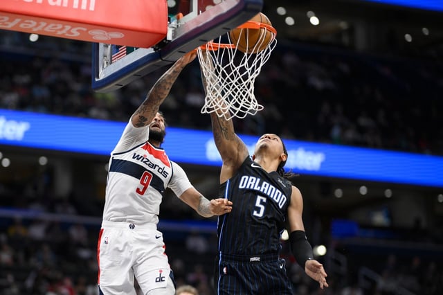 Washington Wizards forward Justin Champagnie (9) goes to the basket against Orlando Magic forward Paolo Banchero (5) during the first half of an NBA basketball game, Thursday, April 3, 2025, in Washington. (AP Photo/Nick Wass)