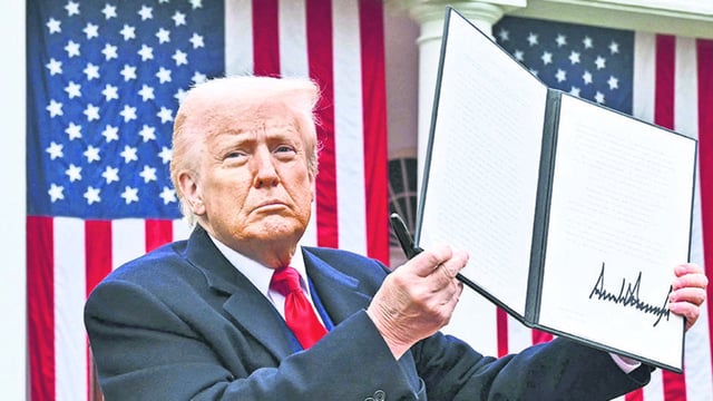 US President Donald Trump holds a signed executive order after delivering remarks on reciprocal tariffs during an event in the Rose Garden entitled Make America Wealthy Again at the White House in Washington, DC, on April 2, 2025. (AFP)