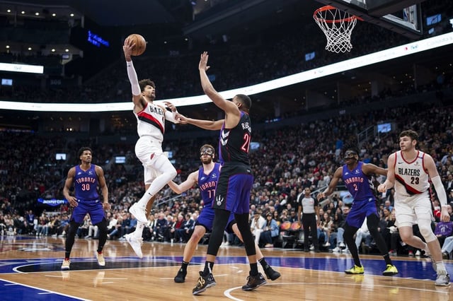 Portland Trail Blazers guard Matisse Thybulle (4) shoots over Toronto Raptors centre Orlando Robinson (21) during the first half of NBA basketball action in Toronto on Thursday April 3, 2025. THE CANADIAN PRESS/Thomas Skrlj