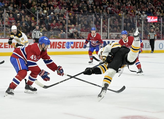 Apr 3, 2025; Montreal, Quebec, CAN; Boston Bruins forward Fabian Lysell (23) shoots the puck and Montreal Canadiens defenseman Alexandre Carrier (45) defends during the third period at the Bell Centre. Mandatory Credit: Eric Bolte-Imagn Images