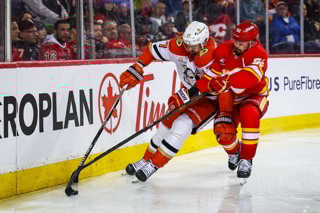 Apr 3, 2025; Calgary, Alberta, CAN; Calgary Flames defenseman MacKenzie Weegar (52) and Anaheim Ducks left wing Alex Killorn (17) battles for the puck during the third period at Scotiabank Saddledome. Mandatory Credit: Sergei Belski-Imagn Images