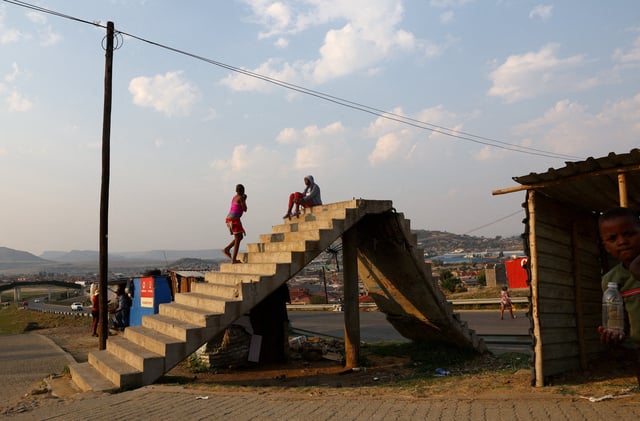 Children play on a damaged pedestrian bridge in a township outside the capital Maseru in Lesotho, October 6, 2022.REUTERS/Siphiwe Sibeko/File Photo