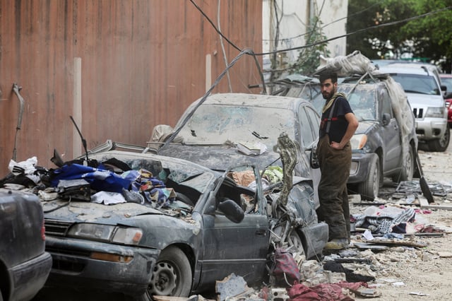 Une personne se tient près de véhicules endommagés à la suite d’une frappe aérienne israélienne, à Beyrouth, le 1er avril 2025