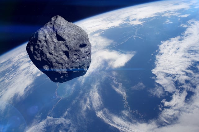 A stock image shows an asteroid whizzing past the Earth as seen from space.