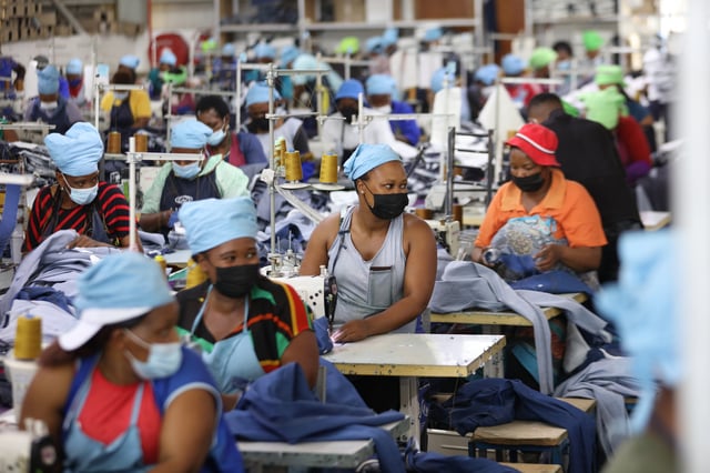 FILE - Matumelo Manosa, center, works in a garment factory in Maseru, Lesotho, Thursday, Feb. 24, 2022. (AP Photo/Neo Ntsoma, file )