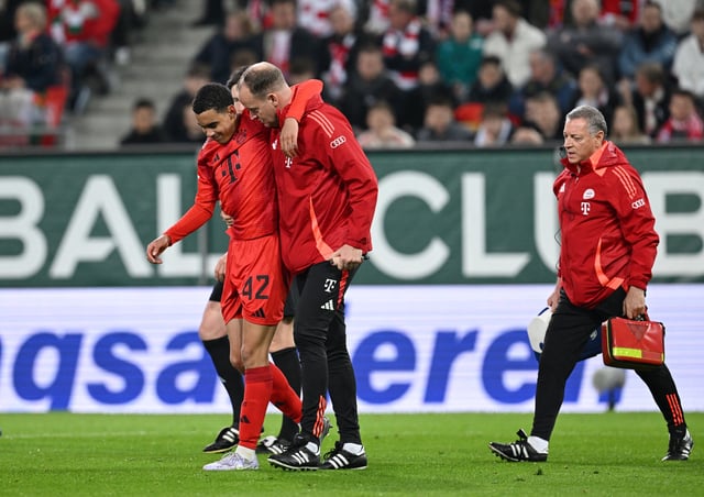 Soccer Football - Bundesliga - FC Augsburg v Bayern Munich - WWK Arena, Augsburg, Germany - April 4, 2025 Bayern Munich's Jamal Musiala receives medical attention after sustaining an injury REUTERS/Angelika Warmuth