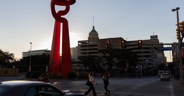 Pedestrians walk by La Antorcha de la Amistad sculpture in downtown San Antonio on Nov. 2, 2021.