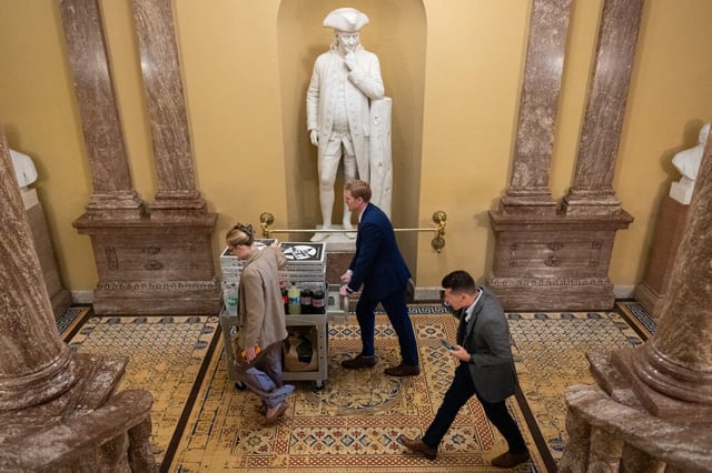 Staffers wheel pizzas through the Capitol as the Senate prepares to begin its vote-a-rama on the GOP’s budget resolution on Friday evening.