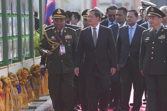 Cambodian Prime Minister Hun Manet, second from left, visits a photo exhibition during an official inauguration of the Ream Naval Base in Sihanoukville, southwestern of Phnom Penh, Cambodia, Saturday, April 5, 2025. (AP Photo/Heng Sinith)