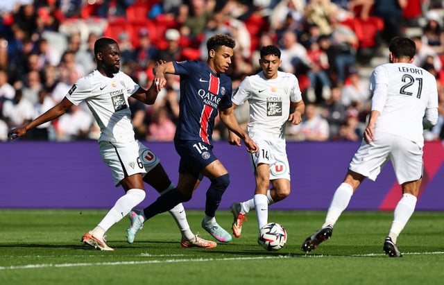 Soccer Football - Ligue 1 - Paris St Germain v Angers - Parc des Princes, Paris, France - April 5, 2025 Paris St Germain's Desire Doue in action with Angers' Jean-Eudes Aholou REUTERS/Gonzalo Fuentes