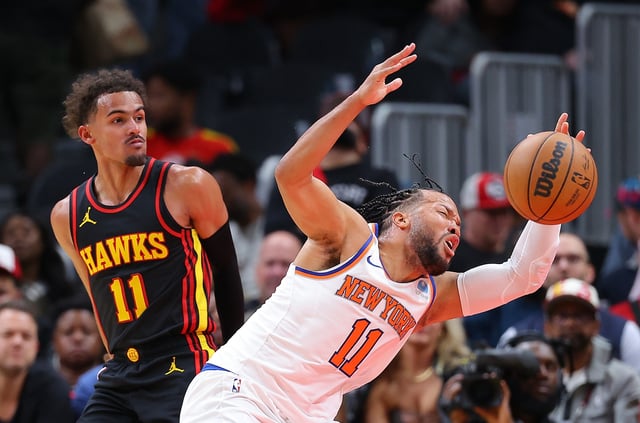 Jalen Brunson #11 of the New York Knicks draws a foul from Trae Young #11 of the Atlanta Hawks during the fourth quarter at State Farm Arena on October 27, 2023 in Atlanta, Georgia.