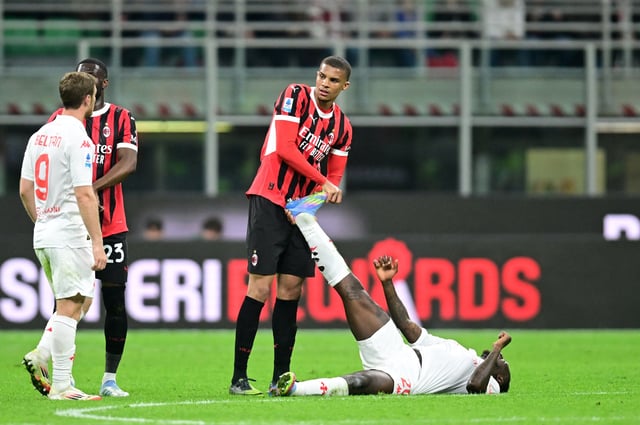 Soccer Football - Serie A - AC Milan v Fiorentina - San Siro, Milan, Italy - April 5, 2025 AC Milan's Malick Thiaw helps Fiorentina's Moise Kean REUTERS/Daniele Mascolo