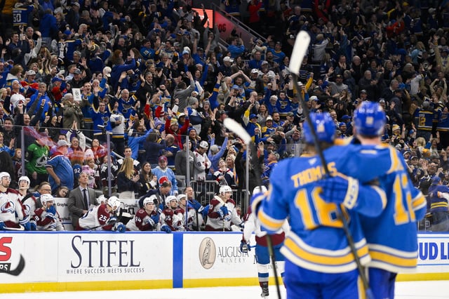 Apr 5, 2025; St. Louis, Missouri, USA;  Fans celebrate after St. Louis Blues center Robert Thomas (18) scored an empty net goal against the Colorado Avalanche at Enterprise Center. The Blues would go on to defeat the Avalanche and record a franchise record 12th straight win. Mandatory Credit: Jeff Curry-Imagn Images