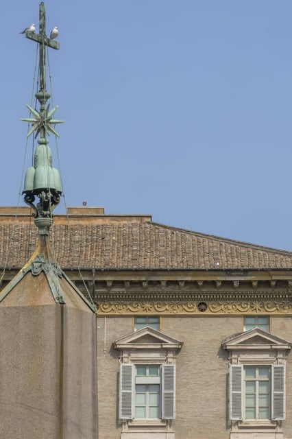 Two seagulls sit on the arms of the cross surmounting the obelisk in front of the window from where Pope Francis used to bless the faithful gathered in St. Peter's Square at The Vatican on Sundays, during a mass, Sunday, April 6, 2025, part of the jubilee of the sick and the health workers. (AP Photo/Andrew Medichini)