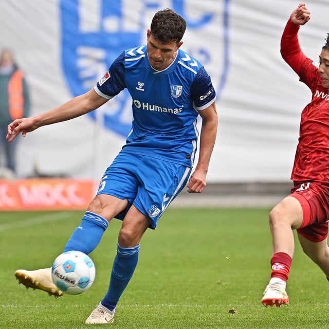 Magdeburgs Tobias Müller (l) und Kaiserslauterns Daisuke Yokota kämpfen um den Ball. 