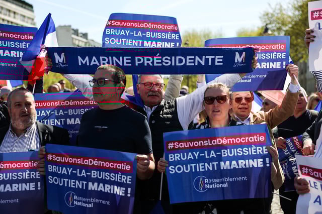 People attend a rally in support of French far-right leader Marine Le Pen, after calls for a peaceful mobilisation following Marine Le Pen's conviction for embezzlement of EU funds, resulting in her being barred from running for office for five years, in Paris, France, April 6, 2025. REUTERS/Gonzalo Fuentes