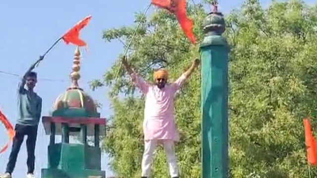 Activists holding saffron flags atop the dargah.