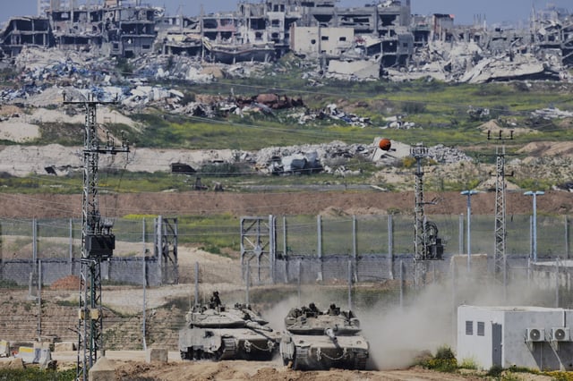 FILE - Israeli tanks maneuver along the border with north of the Gaza Strip, as seen from southern Israel, March 18, 2025. (AP Photo/Ohad Zwigenberg, File)