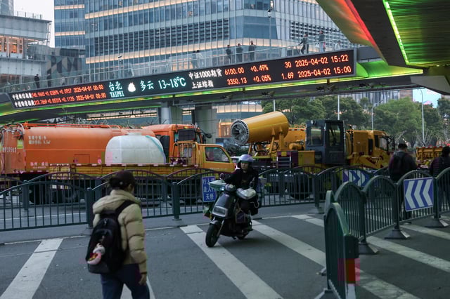 An electronic board shows stock indices at the Lujiazui financial district in Shanghai, China April 2, 2025.  REUTERS/Go Nakamura/File Photo
