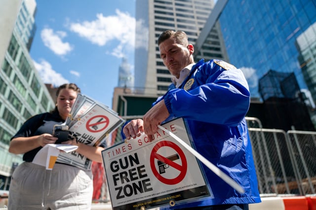 New York City police officers instal signs that read "gun free zone" at Times Square as new gun laws are due to come into effect, in New York, U.S., August 31, 2022. REUTERS/David 'Dee' Delgado/File Photo