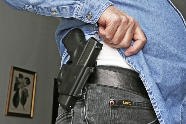 Hank Johnson displays his Glock handgun on his belt in 2013 at his home in  Springboro, Ohio. Johnson got his license to carry a concealed weapon in November 2012.