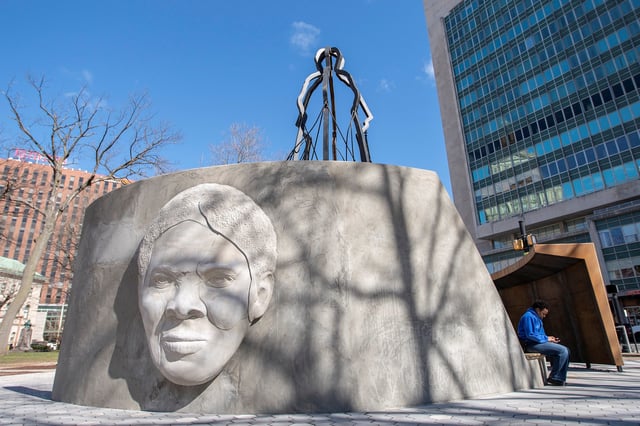 A person sits next to the Harriet Tubman Monument before the unveiling ceremony at Harriet Tubman Park in Newark, New Jersey, U.S., March 9, 2023.