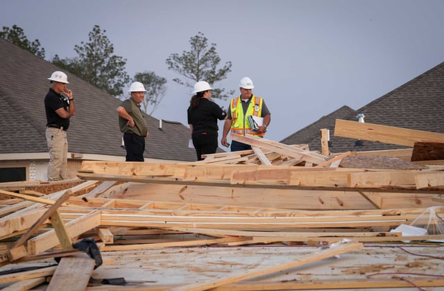 Officials from Lennar homebuilders talk with a compliance officer from the Occupational Safety and Health Administration, at right, at the site where a home under construction collapsed in high winds Tuesday, May 23, 2023, in Conroe.