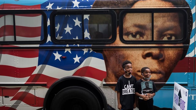 TOPSHOT - People walk by a bus with a mural of US abolitionist and former slave  Harriet Tubman on it, as they arrive to attend the public viewing for George Floyd at the Fountain of Praise church in Houston, Texas on June 8, 2020.