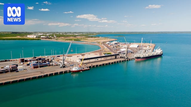 An aerial view of a wharf part of the Darwin Port, with the city of Darwin in the distance.