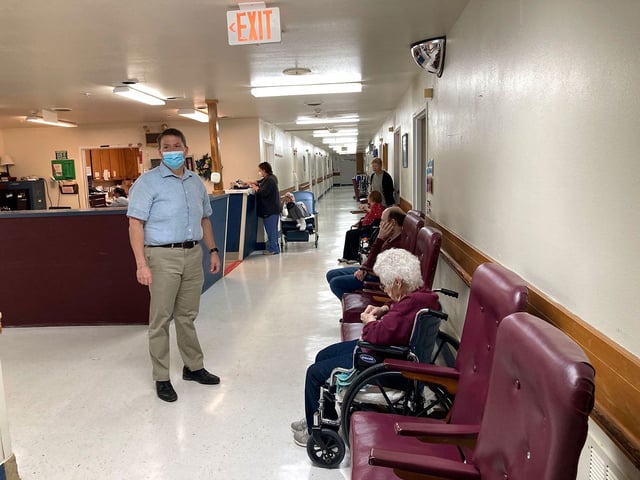 Tim Corbin, left, the administrator of Truman Lake Manor, passes through the hallway of the nursing home on Feb. 14, 2023, in Lowry, Mo. The facility was cited in December for a violation of the federal vaccination requirement for health care workers but subsequently came into compliance. Corbin believes it's time for the vaccination mandate to end. (AP Photo/David A. Lieb)