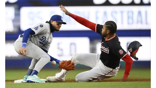 The Washington Nationals’ James Wood, right, steals second base as Dodgers second baseman Miguel Rojas tries to field the throw from home during the first inning on Monday night in Washington. (AP Photo/Nick Wass)