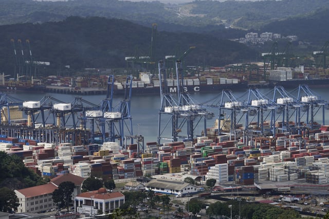 FILE - Cargo containers sit stacked as cranes load and unload containers from cargo ships at the Panama Canal's Balboa port, operated by the Panama Ports Company, in Panama City, Jan. 31, 2025. (AP Photo/Matias Delacroix, File)