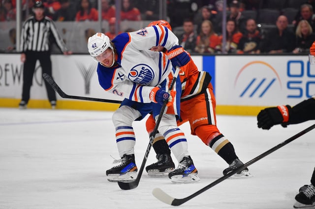 Apr 7, 2025; Anaheim, California, USA; Edmonton Oilers right wing Kasperi Kapanen (42) moves the puck against Anaheim Ducks center Mason McTavish (23) during the third period at Honda Center. Mandatory Credit: Gary A. Vasquez-Imagn Images
