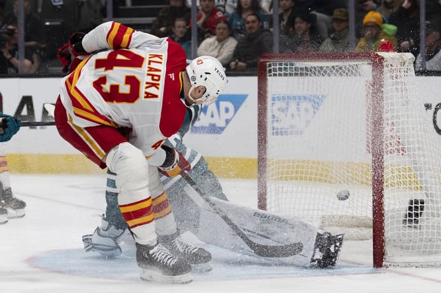 Apr 7, 2025; San Jose, California, USA;  Calgary Flames right wing Adam Klapka (43) shoots the puck past San Jose Sharks goaltender Georgi Romanov (31) during the third period at SAP Center at San Jose. Mandatory Credit: Stan Szeto-Imagn Images