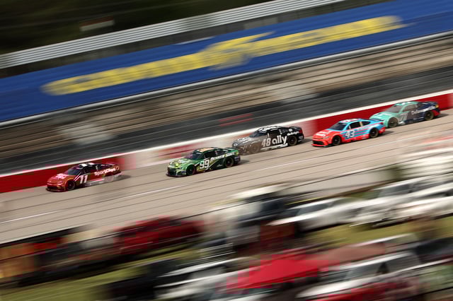 Denny Hamlin, driver of the #11 Sport Clips Haircuts Toyota, leads the field during the NASCAR Cup Series Goodyear 400 at Darlington Raceway on April 06, 2025 in Darlington, South Carolina.